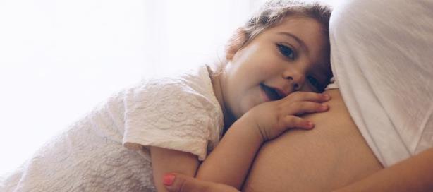 Toddler listens to pregnant mom’s tummy