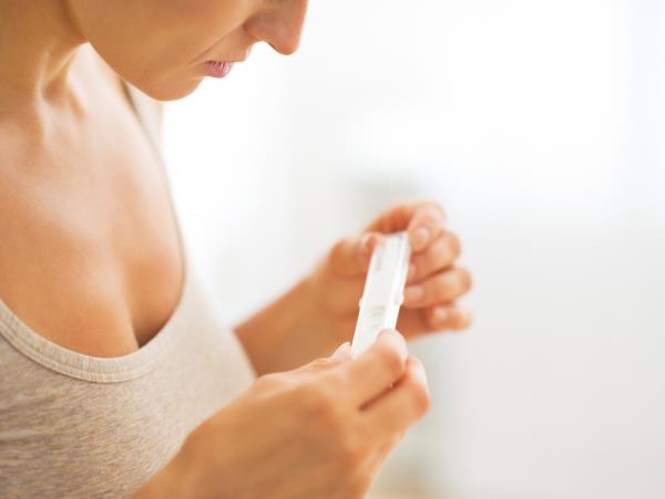 woman looking at home pregnancy test result