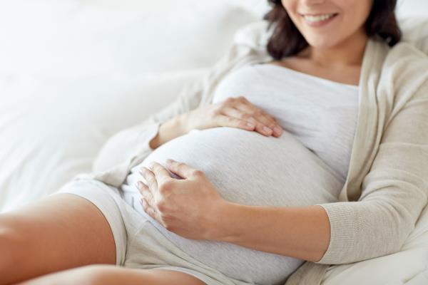 Smiling Pregnant Woman Touching Belly