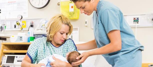 Mother and nurse holding newborn baby